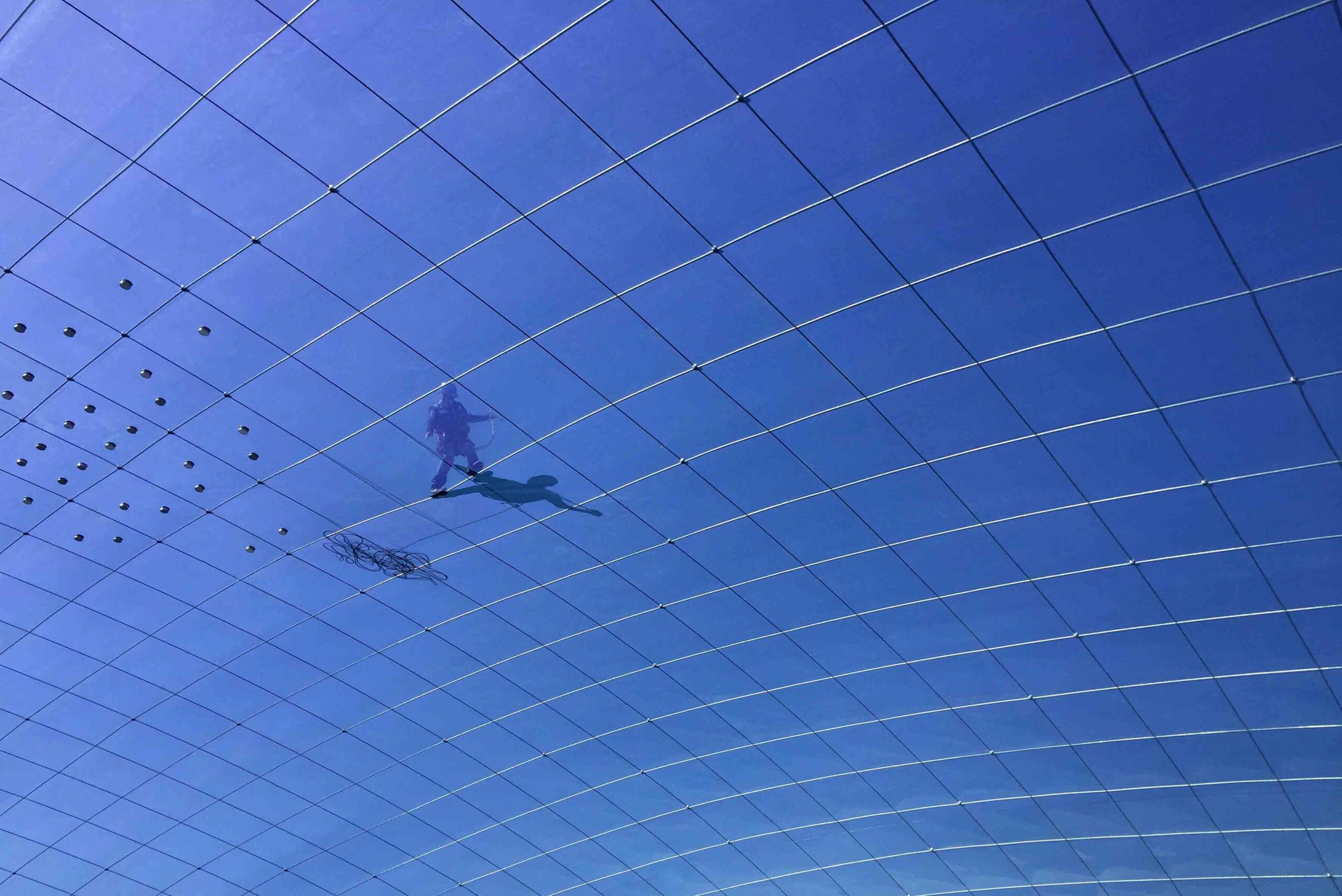 construction-worker-on-etfe-cushion-roof-with-steel-cable-support-blue-sky